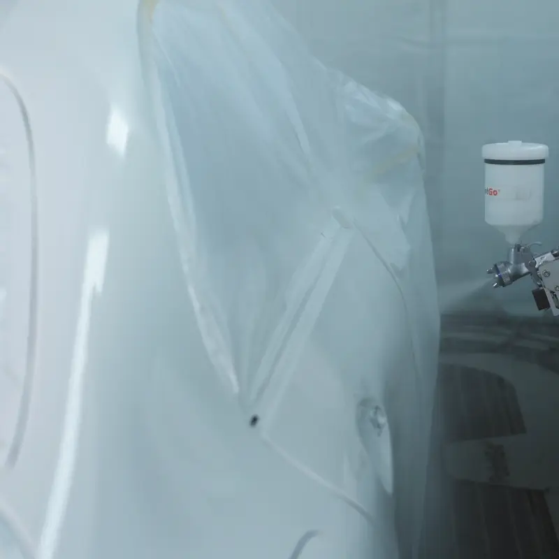 3455-202409181500040043 PaintGo® 90E & 98E | Lackierroboter, Lackierarm mit Spritzpistole und monitertem Lackbecher trägt Farbe auf Karosserieteil eines PKWs auf